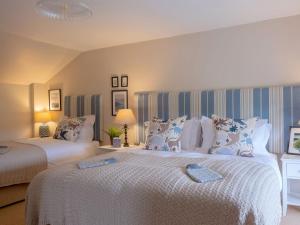 um quarto com 2 camas com edredões brancos em High Ranachan em Campbeltown