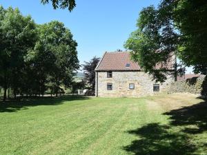 an old stone house with a large grass field at The Cart House in Westerdale