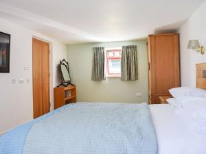 a bedroom with a blue bed and a window at The Cart House in Westerdale