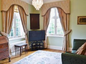 a living room with a tv and two windows at Luppincott Chambers - Hpps in Bideford