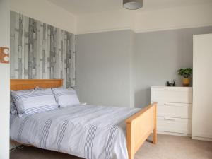 a bedroom with a large bed and a dresser at Pebble Cottage in Felpham