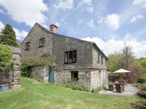 an old stone house on a hill with a patio at Coach House - Uk32684 in Sheepstor