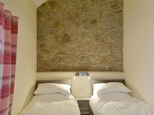 two beds in a room with a stone wall at Milk Churn - Ukc2400 in Luton