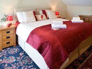 ein Schlafzimmer mit einem großen Bett mit einer roten Decke in der Unterkunft Lynches in Parkham