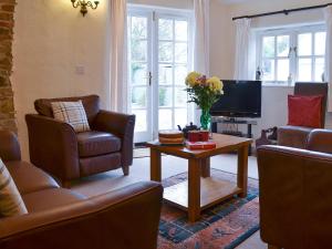 ein Wohnzimmer mit Sofas, einem TV und einem Tisch in der Unterkunft Lynches in Parkham