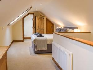 a attic bedroom with a bed and a staircase at Y Glowty in Maenclochog