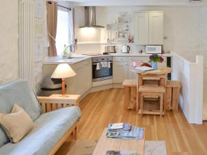 a kitchen with a couch and a table in a room at Hollies Cottage - 27593 in Perranzabuloe