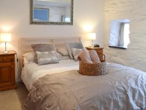 a bedroom with a bed with a mirror on the wall at Hollies Cottage - 27593 in Perranzabuloe