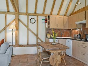 uma cozinha com mesa e cadeiras num quarto em The Old Packhouse em Steyning