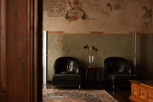 twee zwarte lederen stoelen in een kamer met een tafel bij Hotel Copernicus in Krakau