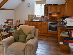 a kitchen with a couch and a chair in a room at Thimble Cottage in Hartland