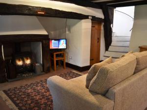 a living room with a couch and a fireplace at Scot Beck Cottage in Troutbeck