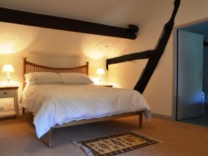a bedroom with a large bed with white sheets at Scot Beck Cottage in Troutbeck