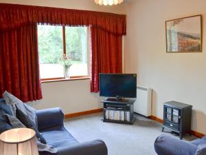 a living room with a couch and a television at Violets in Tonbridge