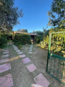 a garden with a gate and a stone pathway at -EXCLUSIVE PRIVATE VILLA- Villasimius in Villasimius
