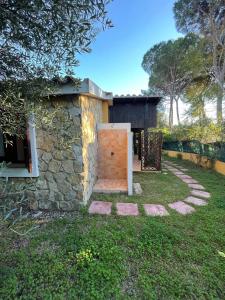 a building with a wooden door in a yard at -EXCLUSIVE PRIVATE VILLA- Villasimius in Villasimius