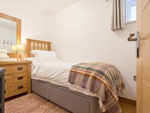 a bedroom with a bed with a dresser and a mirror at The Bunker in Sennen