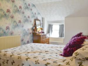Llanfaelrhys的住宿－Ty Hen，一间卧室,床上有紫色填充动物