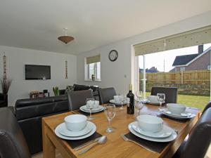 a dining room with a table with chairs and a couch at 6 Jubilee Close in Saint Merryn