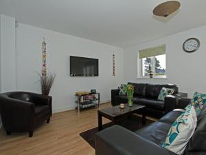 a living room with black leather furniture and a tv at 6 Jubilee Close in Saint Merryn