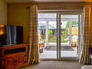 uma sala de estar com uma porta de vidro deslizante em Dovecote Annex em Mablethorpe