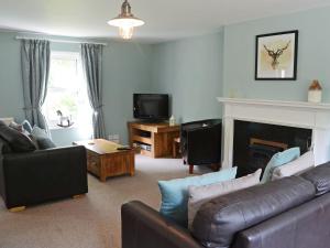 a living room with a couch and a fireplace at Garden Cottage in Tain