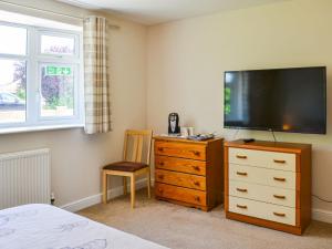um quarto com uma cómoda e uma televisão de ecrã plano em Dovecote Annex em Mablethorpe