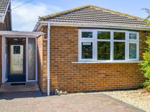 a brick house with a blue door and windows at Dovecote Annex in Mablethorpe