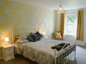 um quarto com uma cama com papel de parede amarelo em Garden Cottage em Tain