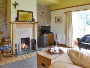 a living room with a fireplace and a tv at Hume Orchard Steading in Hume