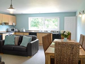 uma sala de estar com um sofá e uma mesa em Garden Cottage em Tain