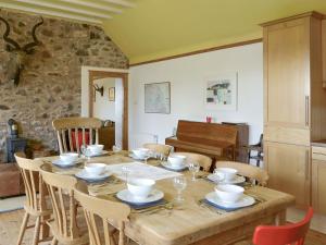 ein Esszimmer mit einem Holztisch und einem Klavier in der Unterkunft Hume Orchard Steading in Hume