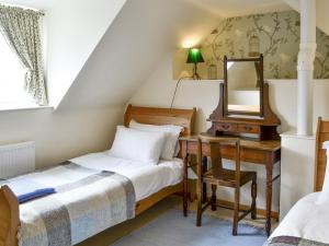 Schlafzimmer mit einem Bett, einem Schreibtisch und einem Spiegel in der Unterkunft Hume Orchard Steading in Hume
