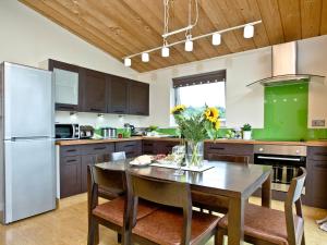 a kitchen with a table and chairs and a refrigerator at Garfield Lodge in Hawkchurch