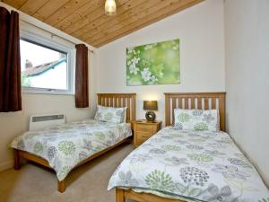 - une chambre avec 2 lits et une fenêtre dans l'établissement Garfield Lodge, à Hawkchurch