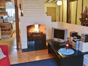 a living room with a fireplace and a television at The Quarter House in Rye