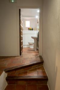a hallway with a bathroom with a toilet and a sink at Cuencaloft Casa S-XVII "La Catedral" in Cuenca