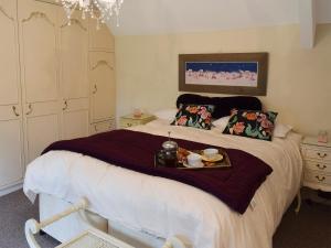 a bedroom with a bed with a tray of food on it at Glebe Farm Cottage in Hornby