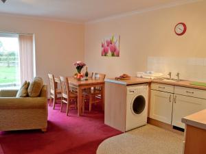 a kitchen and dining room with a table and a washing machine at Trappers in Saint Neot