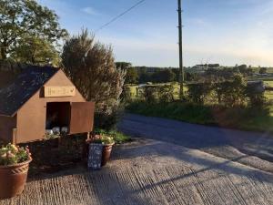 UplawmoorにあるOld Barn Farm Cottageの道路脇に座る犬小屋