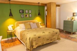 a bedroom with a bed and a green wall at Cuencaloft Casa S-XVII "La Catedral" in Cuenca
