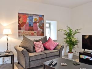 uma sala de estar com um sofá com almofadas em St Ronans Place em Gartocharn