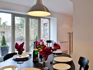 uma sala de jantar com uma mesa com flores vermelhas em St Ronans Place em Gartocharn