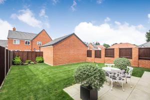 a garden with a table and chairs in a yard at Roma in North Walsham