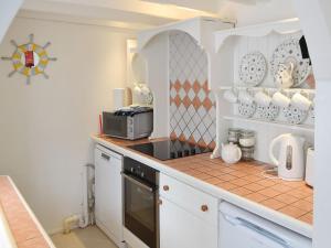 a kitchen with a counter top with a microwave at Beach Corner Cottage in Gorran Haven