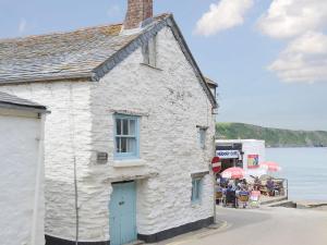 a white building on the side of a street at Beach Corner Cottage in Gorran Haven