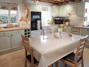 a kitchen with a white table and chairs at The Old Chapel in Aysgarth