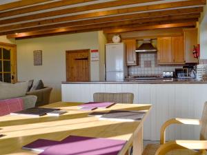 cocina con mesa de madera en una habitación en Meadow Croft, en Llangeinor