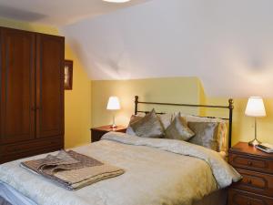 ein Schlafzimmer mit einem Bett mit zwei Lampen und einer Kommode in der Unterkunft Blencathra House in Keswick