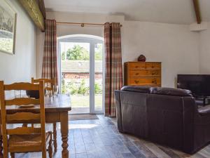 a living room with a couch and a table at The Dairy At Brook House Farm-uk40631 in Church Minshull